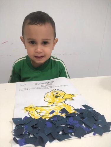 Maternal desenvolvendo a coordenação motora e explorando a estimulação sensorial através da colagem de papel.